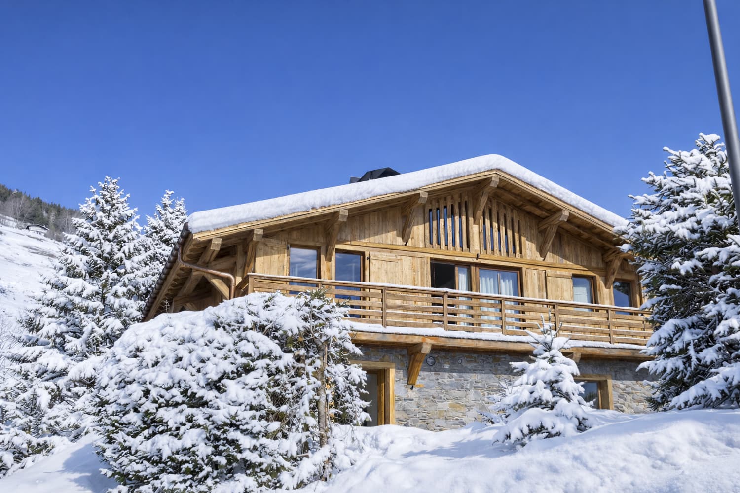 Le chalet sous la neige, entouré de sapins